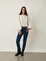 Jean chupín negro de tiro alto, confeccionado en denim con cinco bolsillos tradicionales y cierre frontal con botón y cremallera.