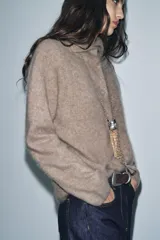 Chaqueta de punto confeccionada en lana, con cuello subido, manga larga y cierre frontal con botones. Presenta un acabado con efecto cepillado.