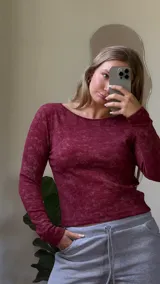 Remera de manga larga con cuello bote, confeccionada en tejido jersey térmico con textura jaspeada.