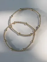 Pulsera elástica de cuentas de 2 y 4 mm en oro laminado 14 kilates.