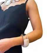 Pulsera rígida de resina italiana, con diseño geométrico y acabado brillante y translúcido en tonos blanco y plateado.