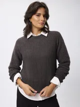 Sweater de tejido acanalado con cuello redondo y manga larga. Presenta un corte relajado y textura estructurada.