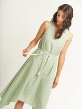 Vestido negro con escote en V y corte irregular con picos en los costados. Incluye lazo de algodón a tono para ajustar en la cintura.