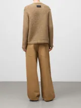 Cárdigan de punto en color camel, con cuello en pico, manga larga y cierre frontal mediante botones. Presenta un diseño de tejido grueso con acabado en canalé en los puños y el bajo.