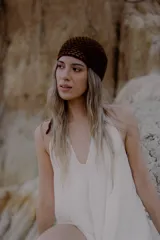 Bandana tejida a crochet con diseño triangular y terminaciones en cordones para anudar. Es un accesorio versátil que puede utilizarse como cinturón o como pañuelo para la cabeza.