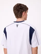 Remera de corte holgado en color negro con detalles en blanco en el cuello y paneles laterales. Presenta logo de la marca estampado en el centro del pecho.