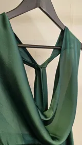Vestido largo de fiesta color verde oscuro, confeccionado en satén, con cuello halter drapeado, espalda descubierta y diseño semi evasé.