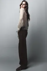 Jeans de tiro alto con pernera recta, confeccionados en denim color marrón oscuro con costuras en contraste. Presentan un diseño frontal con cordones ajustables y bolsillos laterales.