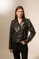 Chaqueta negra de cuero sintético con cuello solapa, cierre frontal asimétrico, bolsillos con cierre y tachas decorativas.