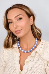 Collar corto compuesto por cuentas cúbicas de cerámica en tonos azul y blanco, intercaladas con discos de cristal checo.
