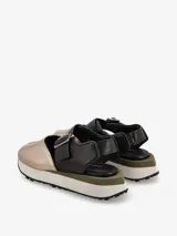 Sandalia de cuero color negro, con tira ancha sobre el empeine con hebilla metálica ajustable, talón cubierto y plataforma con base de goma blanca y suela dentada.