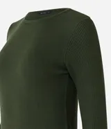 Suéter de punto color rosado, con cuello barco, mangas largas y puños con botones decorativos. El dobladillo también es acanalado.