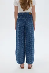 Pantalón jean azul de tiro bajo y corte ancho, con estampado de rayas verticales y diseño floral sutil.