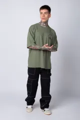 Remera de corte oversize color terracota, con cuello redondo y manga corta. Presenta un estampado circular pequeño en el pecho con motivos orientales.