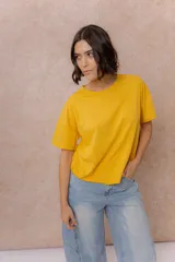 Remera negra de corte oversize con cuello redondo, mangas cortas amplias, hombros caídos y recortes delanteros.