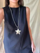 Collar doble con cadena de eslabones plateada, uno corto y otro largo con dije de estrella transparente con estampado de fantasmas.