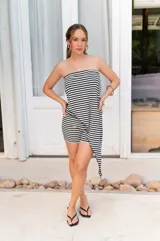 Conjunto de dos piezas en color beige, compuesto por un top strapless con corte asimétrico y un pantalón de corte recto y holgado.