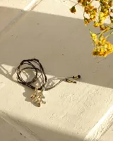 Collar con dije de bronce macizo con forma orgánica irregular, similar a un coral, suspendido de un cordón negro de seda natural anudado.