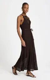 Vestido largo de punto lurex marrón, con escote halter, silueta en línea A, falda translúcida y lazo para ajustar en la cintura.
