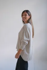 Sweater de punto color beige, de corte holgado y diseño minimalista con cuello redondo y mangas largas.