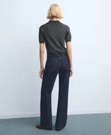 Pantalón de jean de corte recto y tiro medio, en color azul oscuro con costuras en contraste. Presenta cierre frontal con botón y bolsillos laterales y traseros.