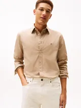 Camisa de popelín de algodón Tommy Hilfiger de corte regular, color beige, con manga larga, cuello camisero y cierre frontal de botones. Cuenta con el logo bordado en el pecho.
