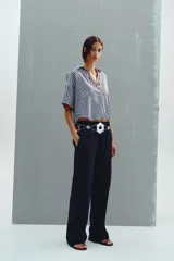 Pantalón de tiro alto confeccionado en lino, con pernera recta, cintura elástica ajustable con cordones y bolsillos delanteros.