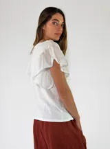 Remera de algodón color blanco, con cuello en V y mangas cortas con volados.