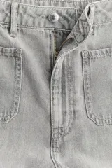 Jean de denim rígido color gris claro lavado, tiro superalto, pierna ancha y corte holgado. Presenta bolsillos parche grandes en la parte delantera y bolsillos parche en la parte trasera. El bajo es largo y sin dobladillo.