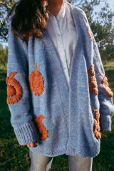 Cárdigan celeste pálido de lana merino con bordados florales color ladrillo hechos a mano.