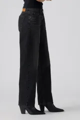 Jeans de corte recto y tiro bajo en color negro con efecto lavado, confeccionados en denim con diseño clásico de cinco bolsillos y cierre frontal con botón y cremallera.