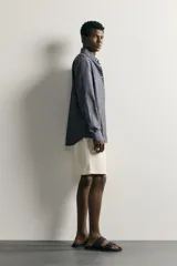 Camisa de corte regular fit confeccionada en tejido de algodón, con cuello solapa, manga larga con puños abotonados, bolsillo plastrón en el pecho y cierre frontal de botones.