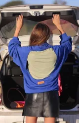 Minifalda plateada de cuero sintético con efecto metalizado, tiro alto, corte ajustado y cierre frontal con botón metálico.