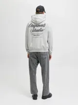 Buzo con capucha de corte holgado, confeccionado en tejido loopback con interior levemente afelpado. Presenta bolsillo canguro frontal y estampados en el frente y la espalda.