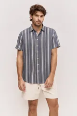 Camisa de manga corta color azul con diseño a rayas verticales, cuello clásico y cierre frontal de botones.