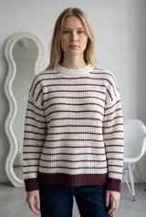 Sweater de tejido de punto con diseño a rayas horizontales en color crema y bordó, de corte holgado, cuello redondo y puños acanalados.