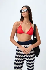 Top de bikini negro con tirantes finos y volados en el borde.