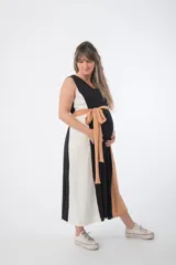 Vestido largo de corte imperio, con paneles verticales en color negro, blanco y ocre. Incluye lazo de tela ocre para ajustar debajo del busto.