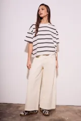 Remera de algodón color crudo con rayas horizontales negras, corte holgado y mangas cortas.