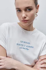 Remera blanca de silueta amplia y calce relajado, confeccionada en tela suave y liviana, con cuello redondo, mangas cortas con vuelta y hombros caídos. Cuenta con un delicado bordado frontal en color azul con la inscripción "LE SOLEIL TOUTE L'ANNÉE sur la Côte d'Azur".