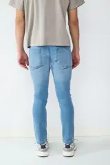 Jean de corte slim fit en color azul claro, con diseño clásico de cinco bolsillos, cierre frontal con botón y cremallera.