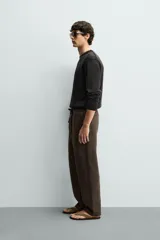 Pantalón de corte regular fit confeccionado en tejido mezcla de algodón, con cintura elástica ajustable mediante cordón, bolsillos laterales y bolsillos traseros de vivo.