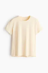 Remera de running en tejido funcional color beige claro, con tecnología DryMove para absorber el sudor, de corte estándar, cuello redondo y mangas cortas.
