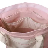 Bolso tipo tote bag color rosa con bolsillo frontal y asas en tono crudo. Cuenta con tiras largas para el hombro y asas cortas de mano, además de un bolsillo delantero con cierre y detalle de argolla metálica.