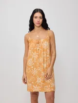 Vestido corto color naranja con estampado de motivos playeros en blanco, de breteles finos y corte suelto.