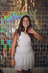 Minivestido blanco con un solo hombro, corte a la cintura y falda con volados.