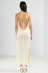 Vestido largo tejido color crema, con cuello halter y espalda baja.