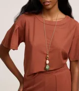 Blusa color ladrillo de tejido piquet con viscosa certificada, modelo t-shirt box, escote redondo y mangas cortas con pliegues.