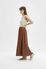 Falda larga de algodón color marrón, con cintura elástica con punto smock y caída amplia.