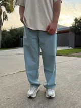 Pantalón de jean estilo baggy, de corte holgado y tiro medio, confeccionado en denim de tela pesada en tono celeste claro.